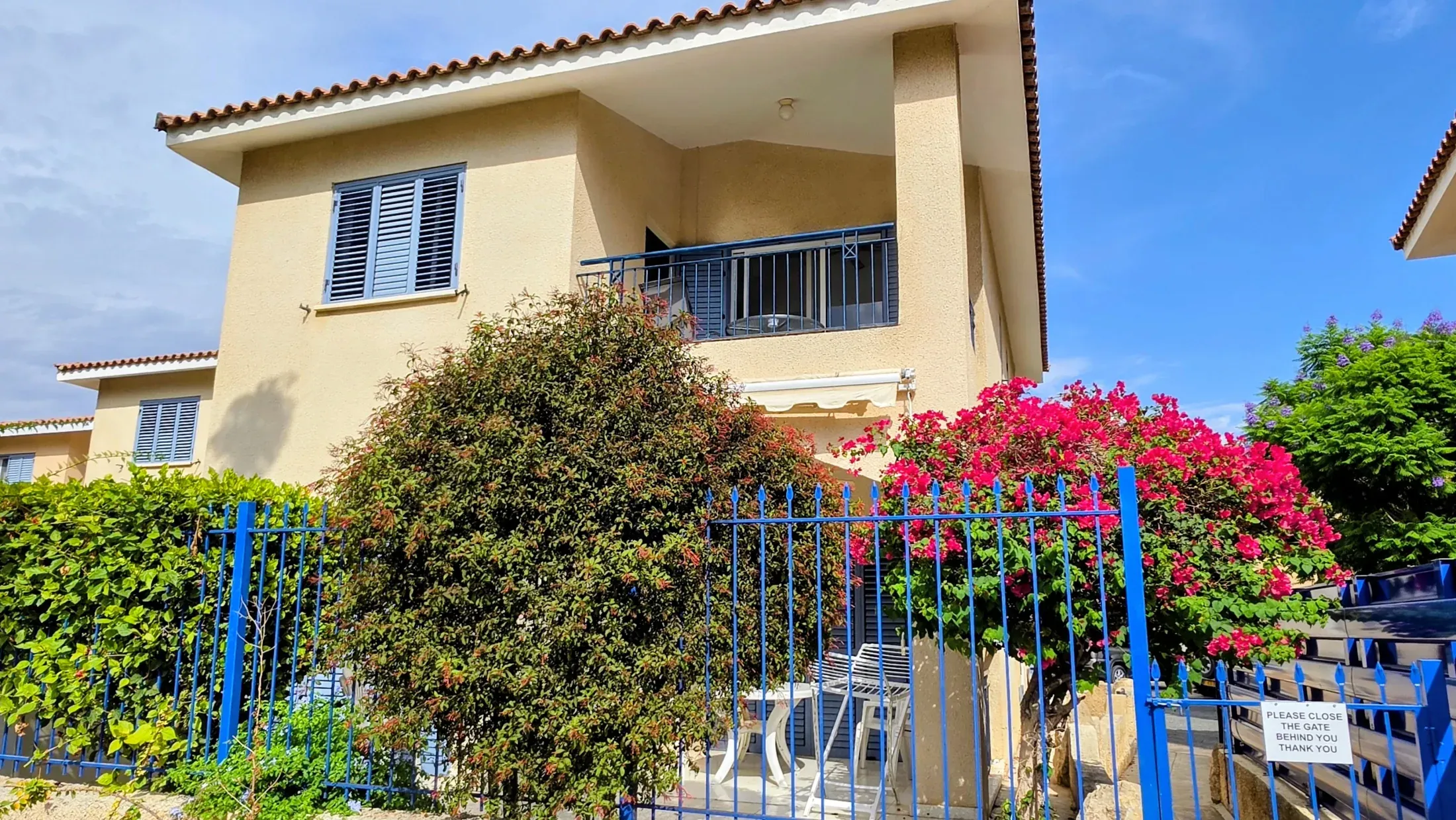 Die Villa Nadezda von der Straße, blühende Bougainvillea über dem blauen Geländer