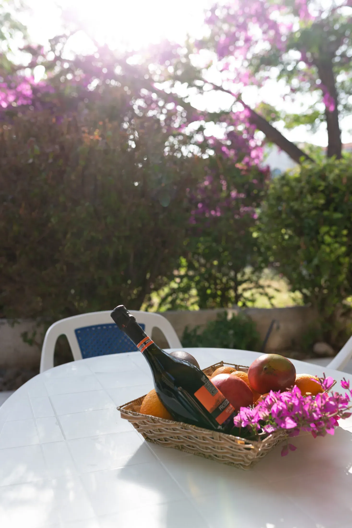 Ein Obstkorb und eine Flasche Prosecco auf dem Terrassentisch